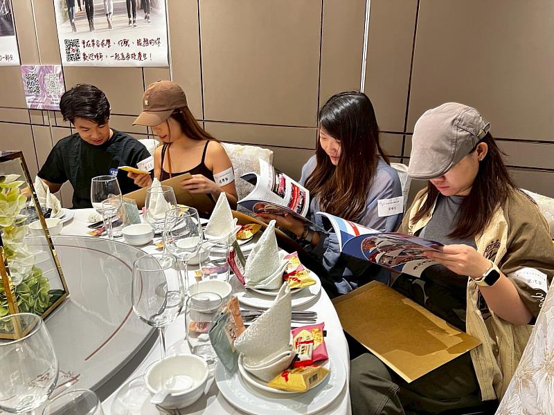 香港校友翻閱校友會總會精心製作的會刊《我世新來的》,回顧母校近年榮耀時刻與校園發展成果。(世新大學提供)