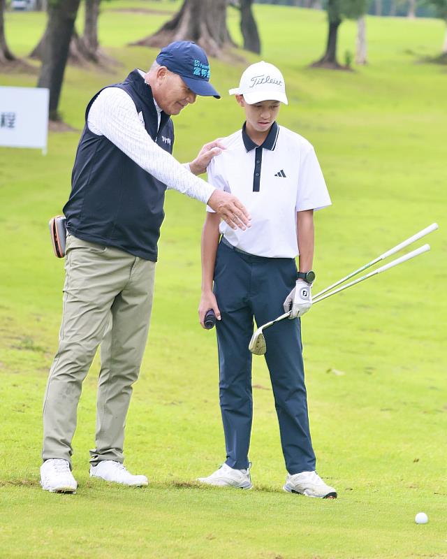 長春選手盧建順（左）在傳承營中指點業餘小將。