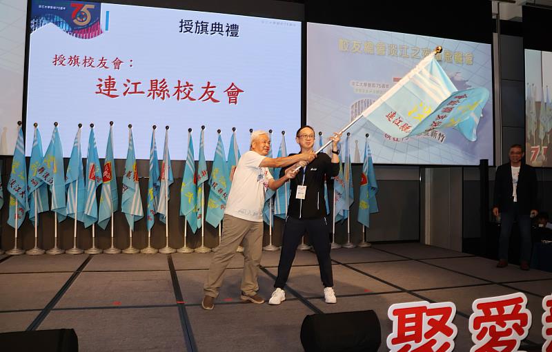 中華民國淡江大學校友總會陳滄江理事長(左)授旗予連江縣校友會。(圖/淡江大學提供)