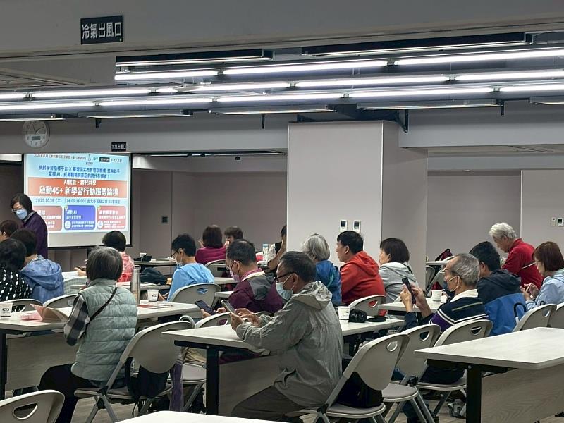 與會的中壯年學習者專注聆聽講者分享，現場舞台以「AI賦能 × 數位孝親 × 終身學習」為主題，展現跨世代學習與科技應用的熱烈交流氛圍。