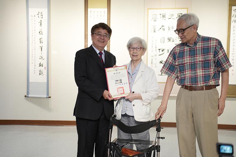 興大詹富智校長（左）頒發感謝狀給王令荃女士（中）。
