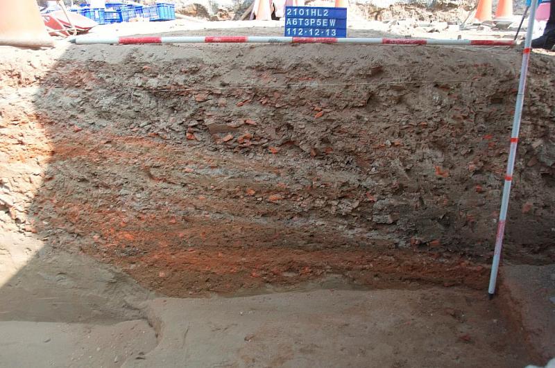 分層夯實的道路剖面，可看見密集糖漏破片