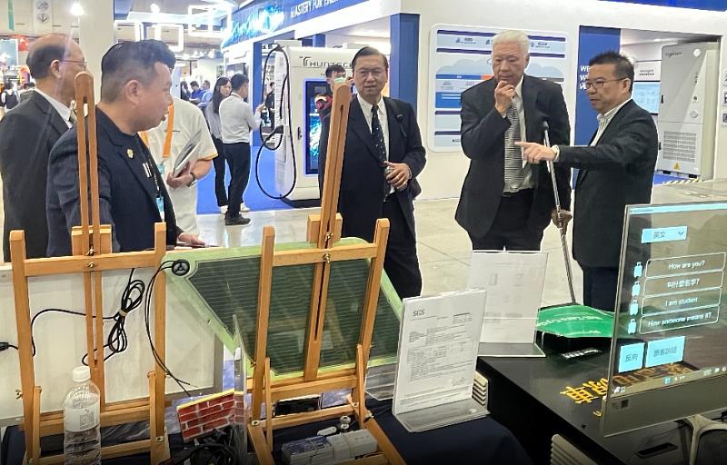 在一起永續科技董事長薛煒立（左2）與參展民眾與廠商現場交流，示範彩繪太陽能的技術與淨零解決方案
