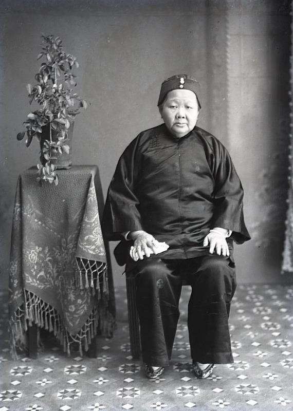 老婦人個人照 1910年代初年放足斷髮運動漸掀起熱潮後，臺灣總督府進而利用保甲制度推動放足斷髮，在保甲規約中明訂，20歲以下纏足女子除了蹠骨彎曲無法復原者外均須放足，女兒絕不可纏足，違約者科以罰金。全臺各地紛紛舉行集體解放纏足大會，1915年8月，全臺放足者已達48萬餘人、纏足者18萬人。照片中的老婦即是獲准保留纏足者。