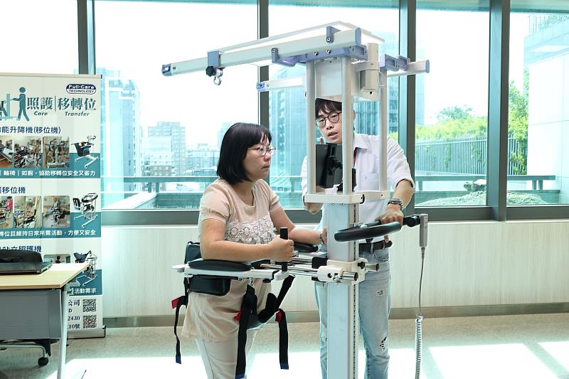 與會民眾體驗扶持步態訓練機，了解長者透過智慧輔助步行的感受。