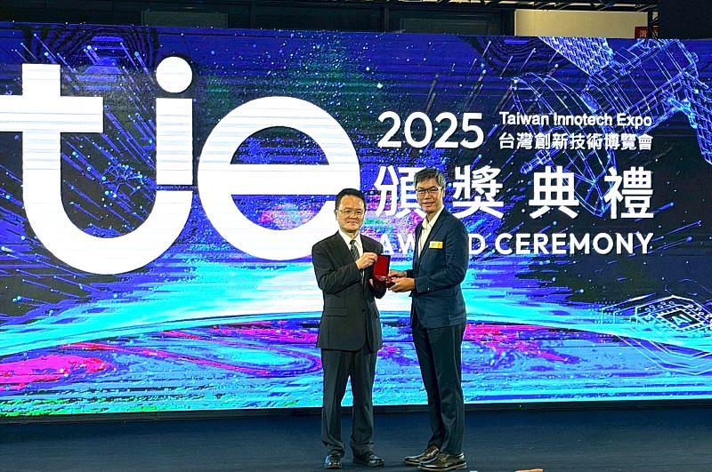 銀牌獎作品「蓋體總成及含彼之滾筒式洗衣機」榮獲表揚。圖為經濟部智慧財產局局長廖承威頒發銀牌獎座予南臺科大財經法律研究所許舜喨副教授。此發明以子蓋體與防水袋體結構，成功解決滾筒洗衣機無法中途加衣的痛點。