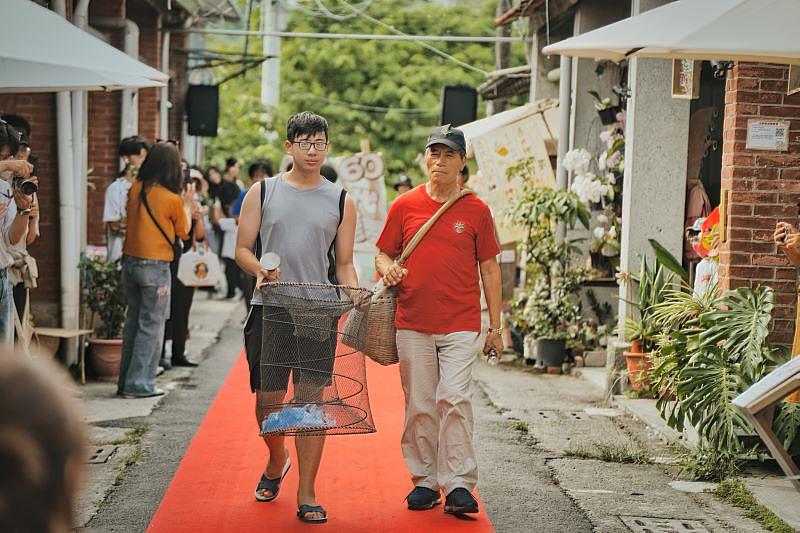 左鎮長老買新景與南臺科大學生，帶著早期捕魚的魚簍和漁網走秀展示。長老回憶年少時在菜寮溪捕魚的溫暖經歷，將個人生活記憶轉化為市集的文化亮點，體現跨世代交流的溫度。