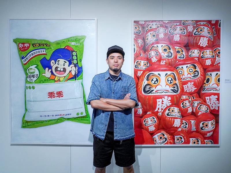 以水彩、油彩跨越插畫與繪畫的界線，賴威帆的創作結合潮流圖像與傳說信仰，是新世代收藏圈注目的藝術家之一。後方兩幅162公分高的作品佔滿牆面，乖乖與達摩並列，形成「信仰與科技的雙螢幕對話」。