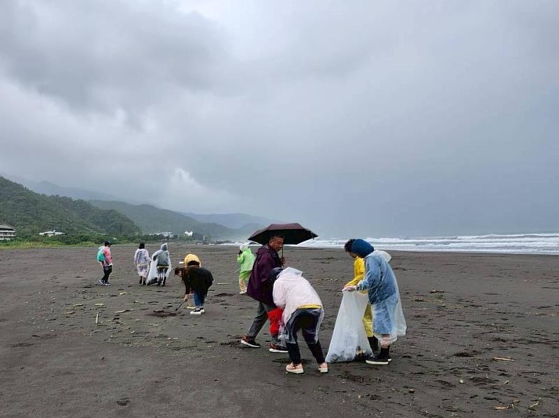 風雨無阻守護海洋　救國團大安區團委會號召淨灘行動。志工雨中撿拾不止歇，用行動守護潔淨海岸。