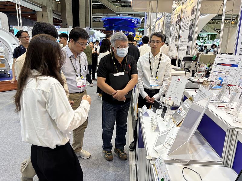 參賽學生向評審詳細介紹作品內容,展示創新與專業能力,評審專注聆聽並進行評分。