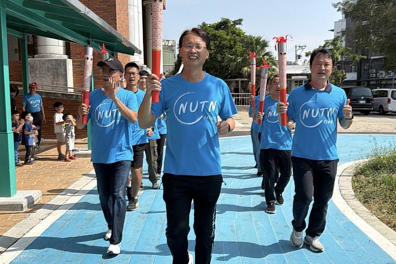 嘉義地區校友手持南大聖火奔跑進場，以行動展現傳承與團結的精神。