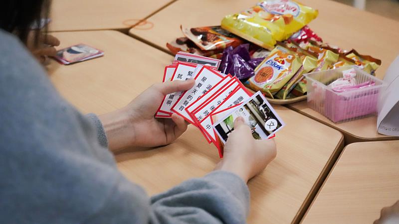 山口大學師生設計的創意歌牌，巧妙融入台灣地標、美食及流行歌曲等內容。（世新大學提供）