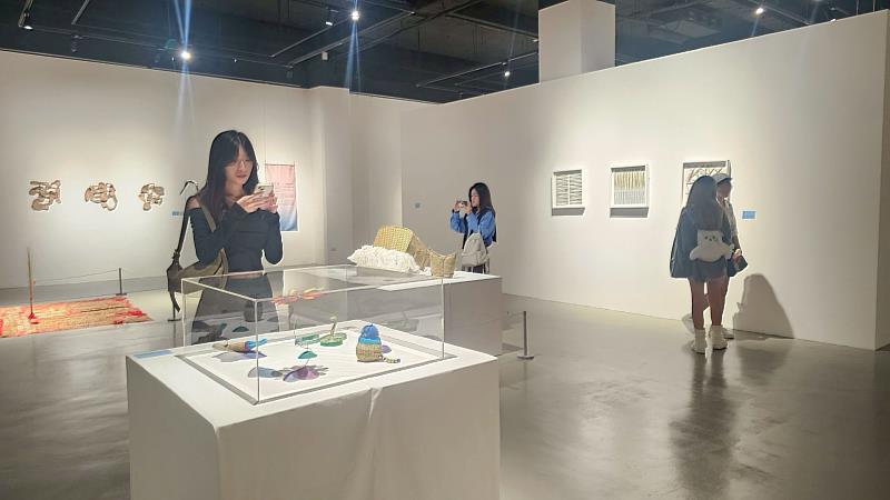 亞大時尚系同學在展區研究各種布料應用。