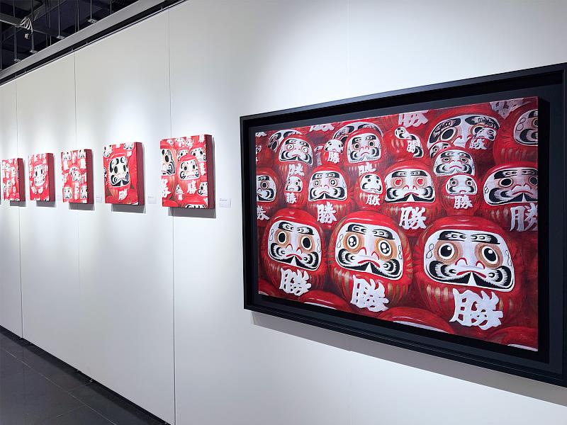 展場達摩不倒翁系列作品一隅，厚實筆觸與紅色能量象徵堅韌與希望，展現賴威帆作品中「溫度感」的力量。