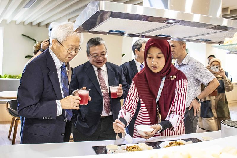 湯明哲校長(左一)在第一學舍「共享食堂」品嚐國際生烹飪的美食。