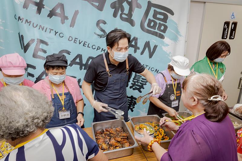 邱臣遠代理市長化身一日志工為長輩盛菜、陪伴共餐。