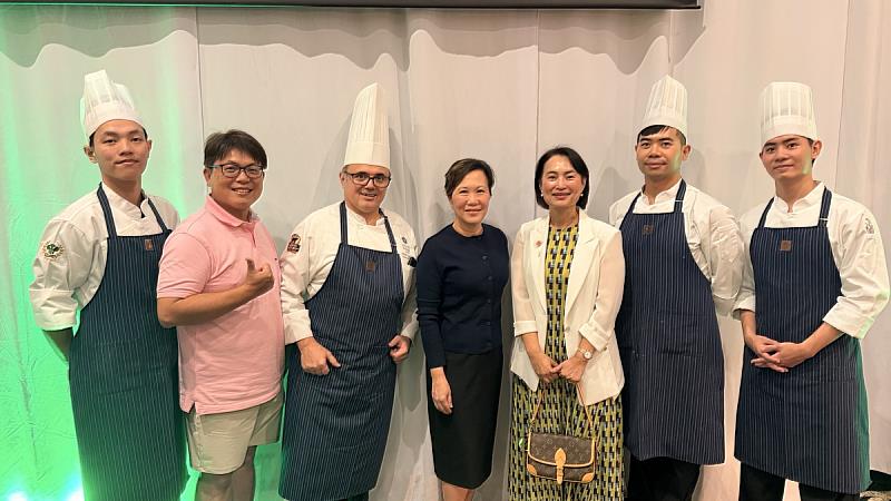 高餐師生與關島凱悅飯店總經理及行政主廚合影。關島凱悅飯店總經理朱思惠（中）、關島凱悅飯店行政主廚Mirko Agostini（左3）、本校前校友會長陳宏志（左2）、本校廚藝學院院長陳紫玲（右3）、本校廚藝學院葉建志老師（右2）。以上本校校友、葉老師及學生皆在凱悅集團實習或工作過。