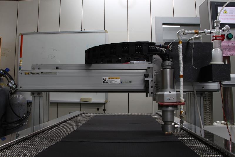 團隊利用常溫常壓電漿技術嘗試將多種金屬氧化物作為儲能反應的催化劑均勻附著於碳材表面，圖為大型噴射式常壓電漿鍍膜設備。