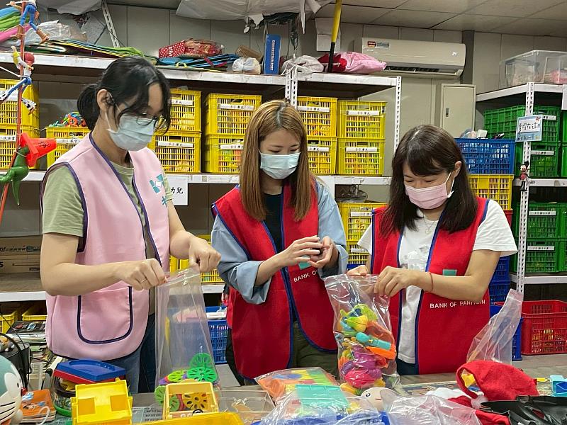 板信商業銀行業務部企劃科長黃依翎（左1）與員工合作整理二手玩具