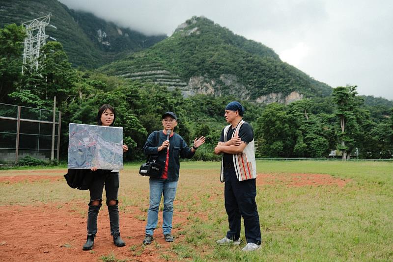 地球公民基金會教育專員劉思怡（左）、地球公民基金會副執行長黃靖庭（中）與反亞泥自救會環保人士白誠實（右）於壘球場講解居住在礦區下的富世村。背後如梯田般的山就是亞泥開採後的礦區。