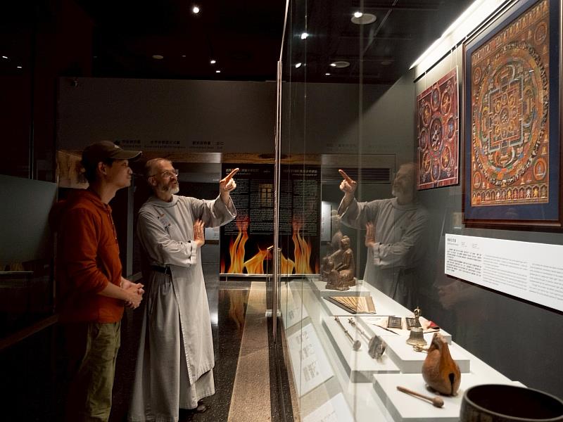 神父對輪展櫃中的佛教文物很感興趣。（圖由世界宗教博物館提供）