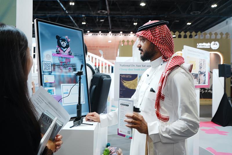 國際友人前來體驗臺灣館的AI導覽機，與臺灣黑熊AI助理一貝兒互動，認識臺灣各個博物館。