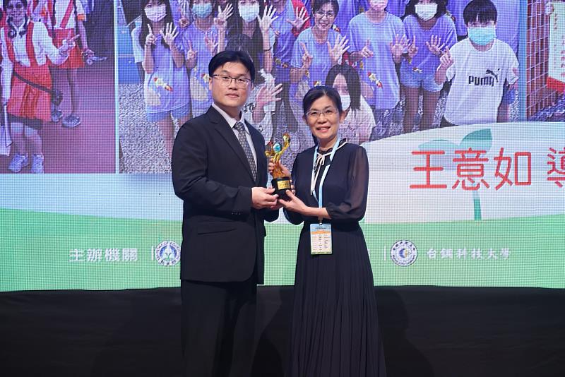 王意如老師從教育部次長朱俊彰手上接獲獎座。