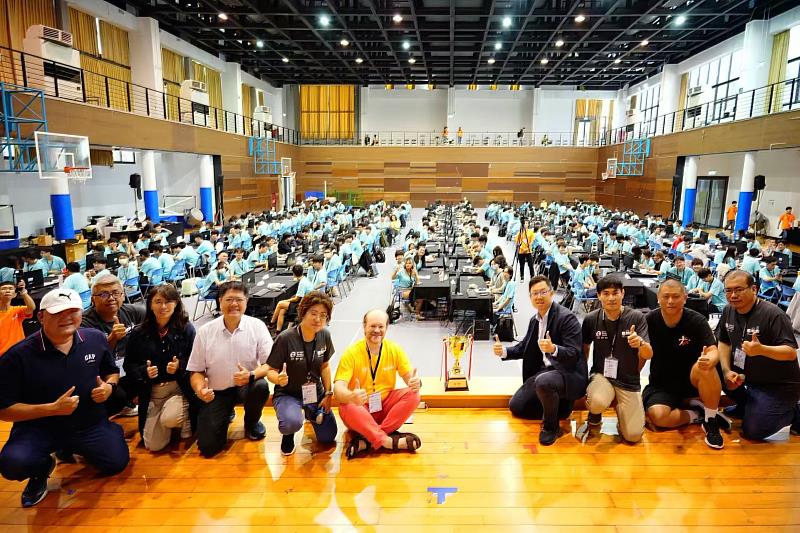 「2025國際大學生程式設計競賽」（ICPC）亞洲區台中站區域競賽落幕，裁判長Peter Rossmanith（前排右5）、來賓台中市數位發展局長林谷隆（前排右4）、大會主席許慶賢（前排右3）等，和主辦單位人員、獲勝隊伍合影。