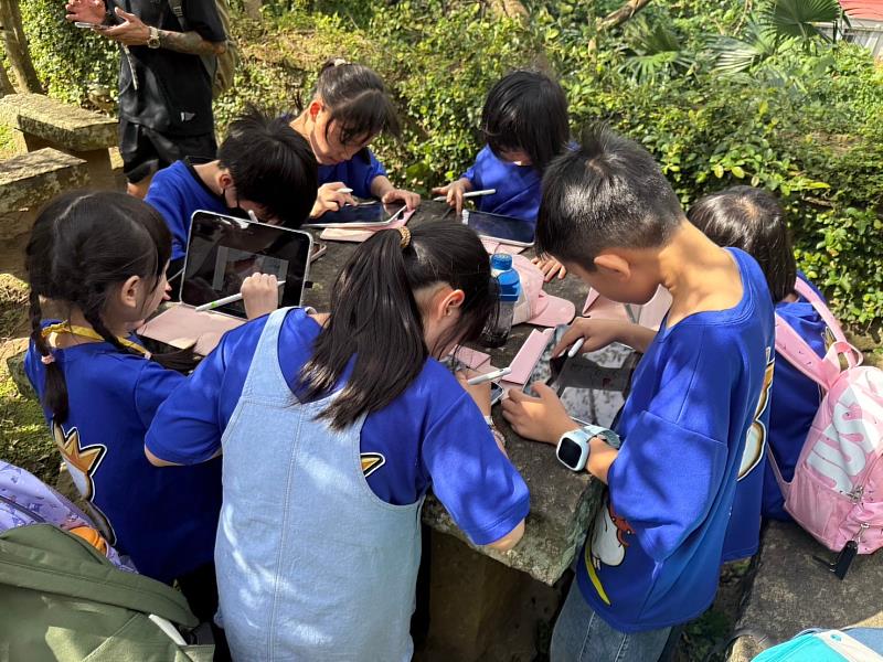 東門國小學生於戶外使用平板進行智慧學習。