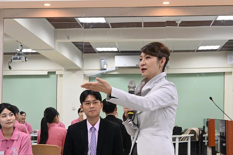 JOJO老師在課程中示範禮賓儀態與應對方式，協助南大團員理解服務細節的標準作法。