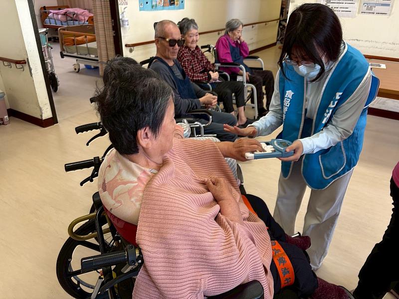 亞大保健系王婕如同學為機構長輩進行握力檢測。