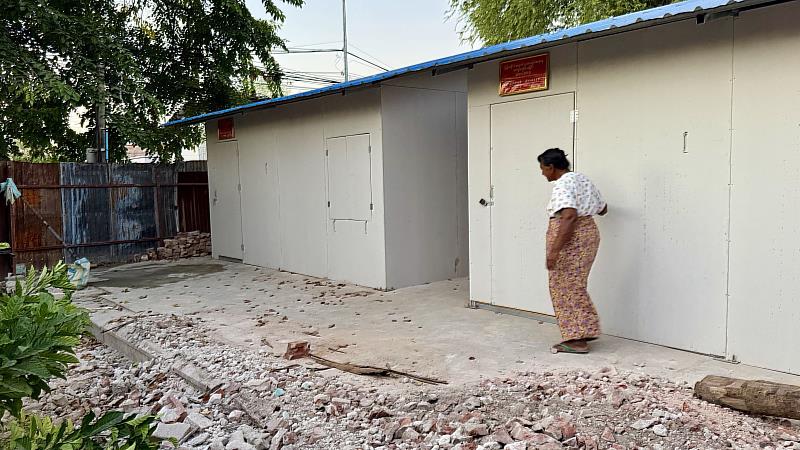 緬甸曼德勒一位74歲受災居民道·欽溫敏於即將入住的組合屋前，查看施工狀況。（圖由靈鷲山佛教教團提供）