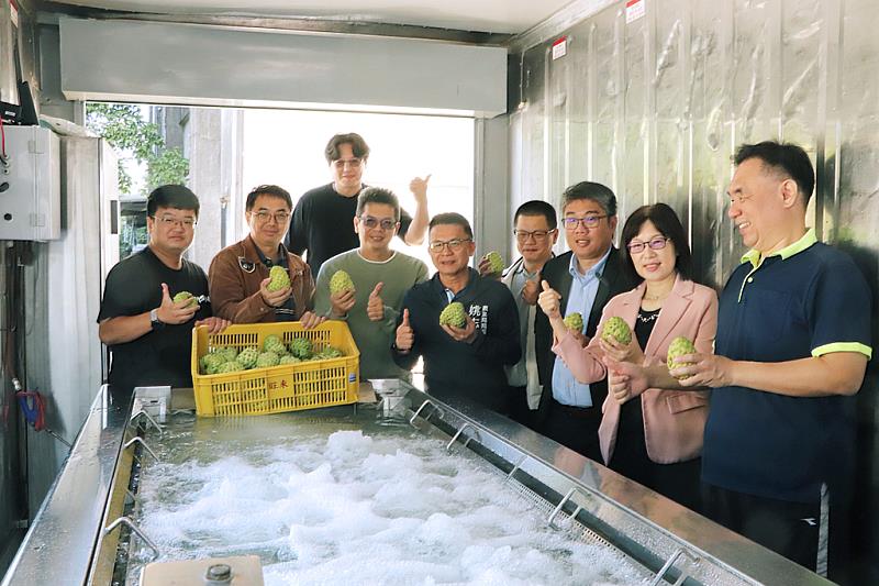 高科大今(22)日發表的「貨櫃式多功能微氣泡水果即時清洗系統」，目前已檢測確認在釋迦、鳳梨的清潔效果。事實上此套微氣泡清洗已有屏東、台東業者安裝使用。圖為今日發表的改良版貨櫃式設備，具有可移動的優點，高雄市農業局長姚志旺(前排左四)也出席參加發表會，親自了解微氣泡清洗設備的各項技術細節。