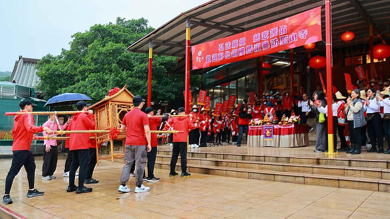 2、聖山寺山門外旗海翻揚，「進唷！進唷！」喊聲與鑼鼓聲不絕於耳。（靈鷲山佛教教團提供）