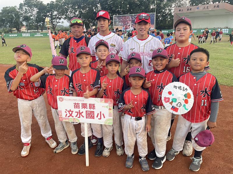 來自苗栗山區的汶水國小棒球隊，小球員與味全龍球員李致霖（後左2）、郭天信（後左3）合影，在徐生明盃賽場留下珍貴回憶。（圖：頂新和德文教基金會提供）
