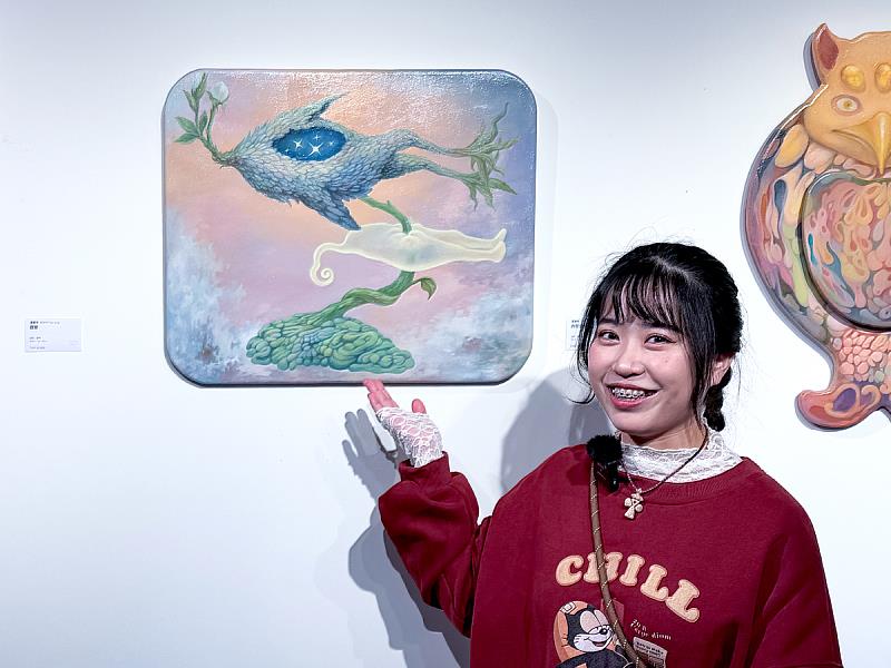 藝術家對著鏡頭解說主視覺《內在生長場》,董晏伶述說,這是描繪「勇氣長大的樣子」的一幅作品。鏡頭捕捉她指向畫面細節的瞬間,像是在訴說每一次生長背後的小小掙扎與亮起的微光。