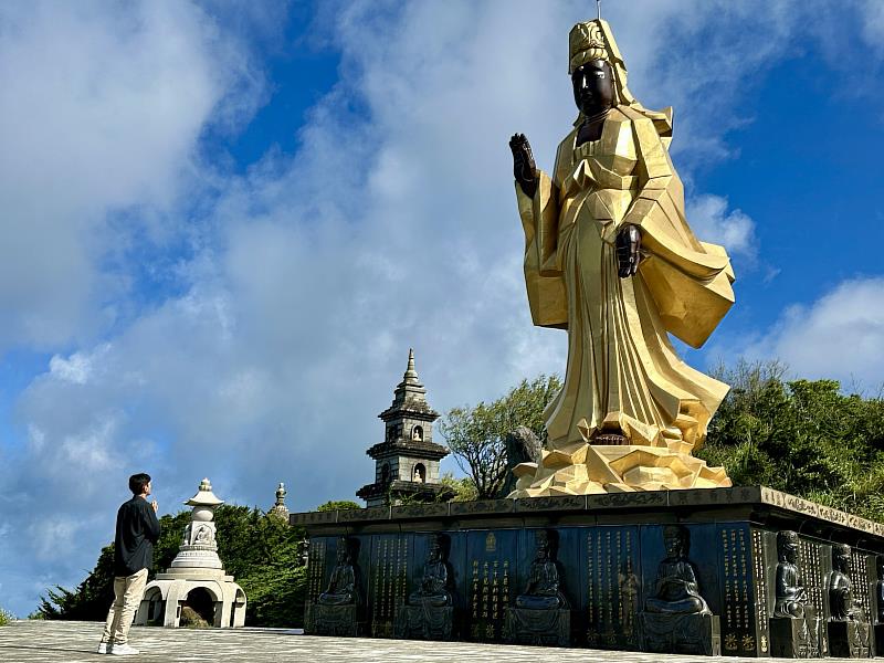 歌手李恩邦在多羅觀音前雙手合十，為災民祈願。（圖由靈鷲山佛教教團提供）