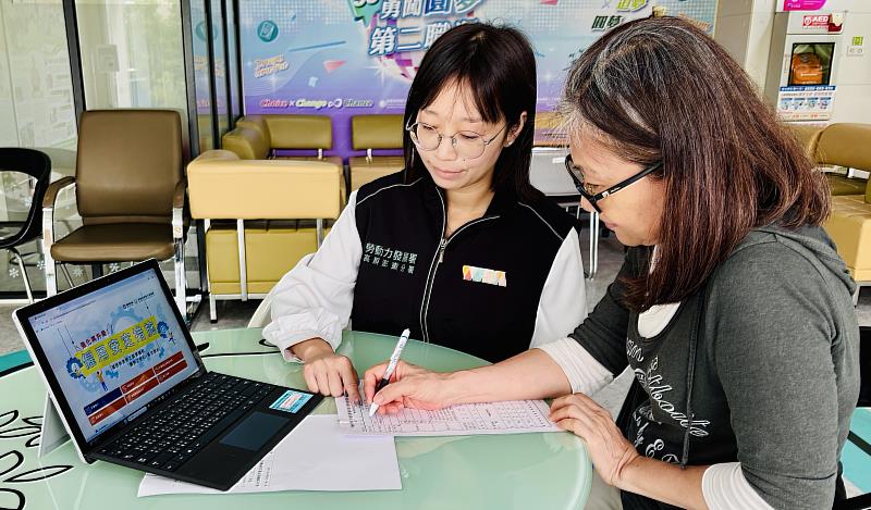 高分署就業服務員向民眾說明如何填寫僱用安定措施申請表。