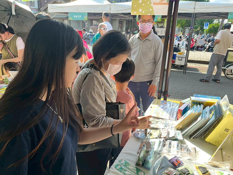 團隊成員為顧客介紹文創商品。