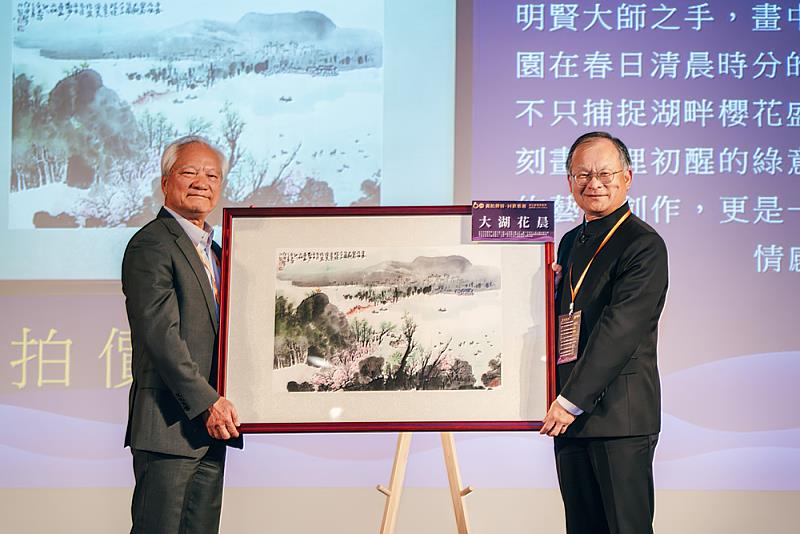 信義公益基金會林信和董事長(左)提供珍貴拍品,獲系友熱烈響應。</p>
<p>台灣水墨大師林明賢作品《大湖春晨》最終以新台幣100萬元拍定,由財團法人華岡法學基金會黃劍輝董事長(右)得標,展現校友對母系的深厚情誼與無私支持。