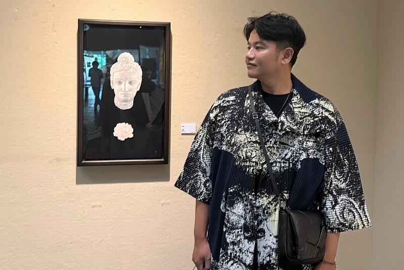 南大校友高義勝於臺南美展獲東方媒材類優選，於展場與得獎作品合影。