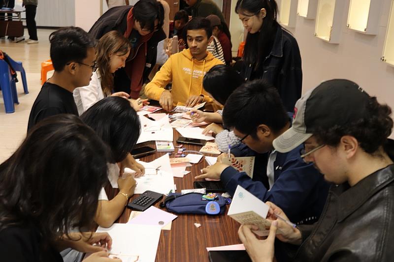 來自世界各地的國際學生專心寫下感恩卡片，手作過程中互相分享素材、交換笑容，語言不同，心卻靠得更近。