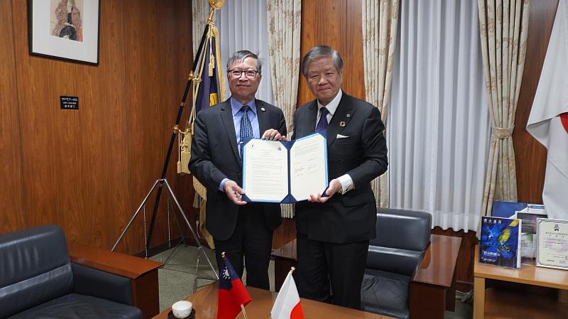 高雄醫學大學校長余明隆（左）與熊本大學校長小川久雄（右）簽署《學術交流合作協議》。