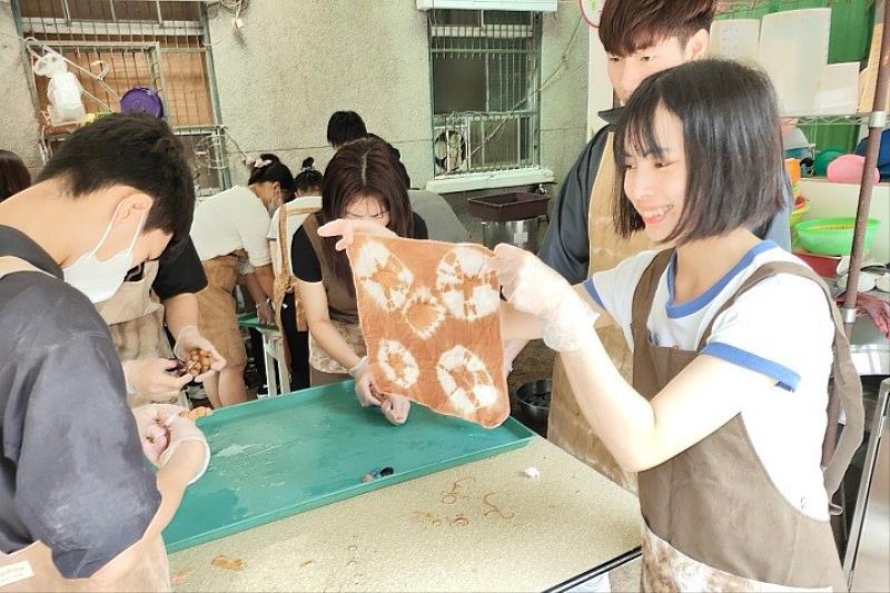 越南籍阮氏紅絨同學參與「新埔柿染體驗課程」，親手製作環保染布，體驗台灣傳統技藝，並深刻理解惜物精神與環保理念。（圖為活動花絮）