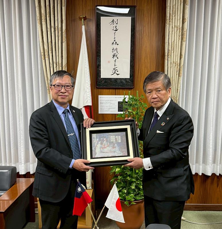 Kaohsiung Medical University President Ming-Lung Yu (left) presents the painting “Love of Skin-Graft,” which represents the spirit of KMU, to Kumamoto University President Hisao Ogawa (right).