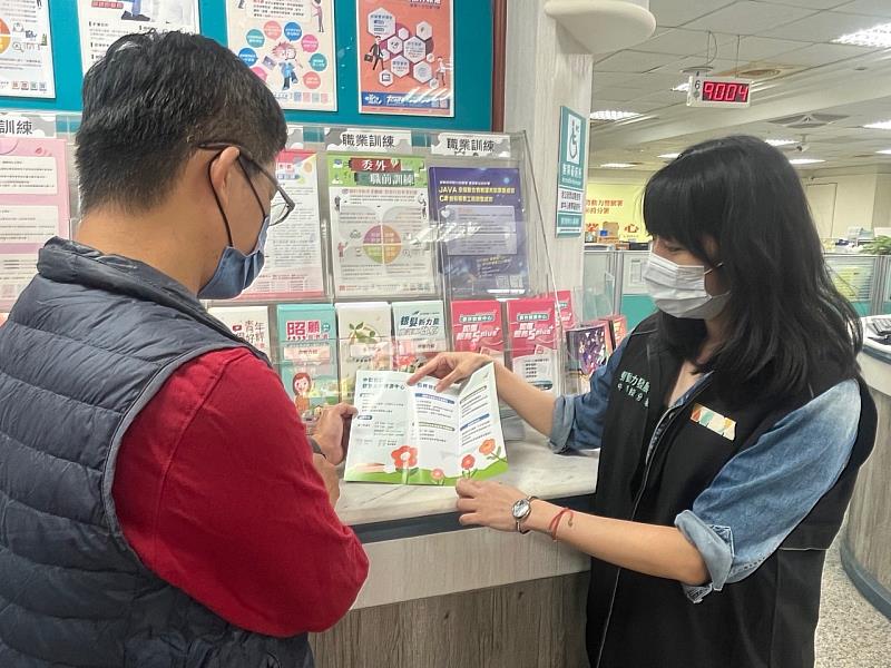 就服員向民眾說明勞工就業通計畫。