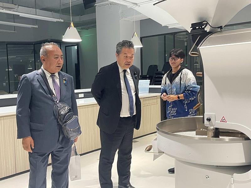 餐飲系學生為參訪團貴賓介紹國際咖啡認證中心環境。