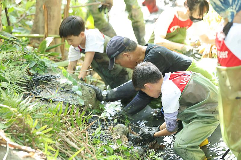 滙豐志工著青蛙裝下溝渠清除雜草與垃圾，讓冬季候鳥來臨時能有更適宜的棲息環境。