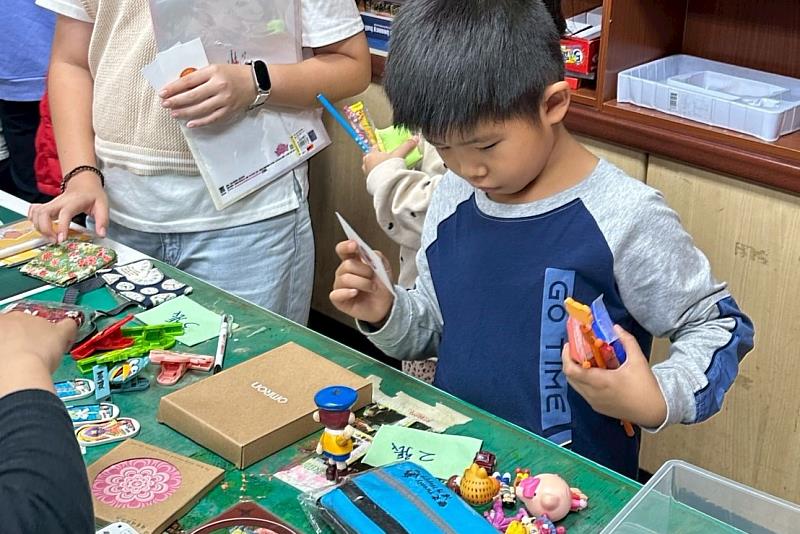 南大聯電課輔中心二手惜物交換活動中，學童與好朋友專心討論要兌換的物品，展現珍惜與選擇的學習歷程。