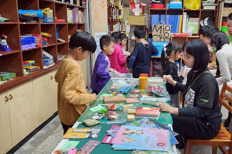 南大聯電課輔中心二手惜物交換活動準備多樣文具與生活用品，學童依需求以發票兌換實用物資。